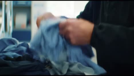 a close-up look at the hands of a person sorting laundry with care, focusing on different fabrics and colors in a bright laundry room environment