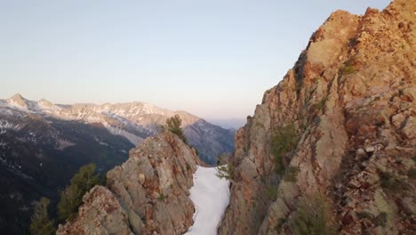 flying over a mountain ridge in the spring time near ski resorts in little cottonwood canyon