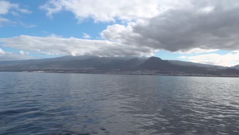 Insel-Teneriffa,-Gesehen-Von-Einem-Feribot-Im-Sommer-Mit-Blauem-Himmel-Und-Dicken-Weißen-Wolken,-Spanien