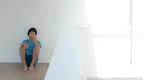 Teenage-Asian-boy-sits-thoughtfully-in-a-bright-room,-with-copy-space