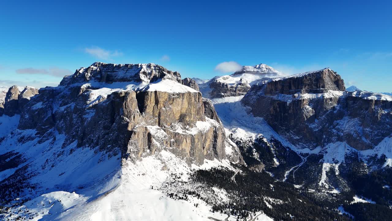 Rock formation in the Italian Dolomites covered in snow during winter (drone footage)
