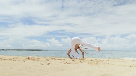 guy dancing capoeira on the beach