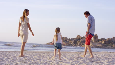 Familia-Feliz-Jugando-En-La-Playa-Al-Atardecer-De-Vacaciones