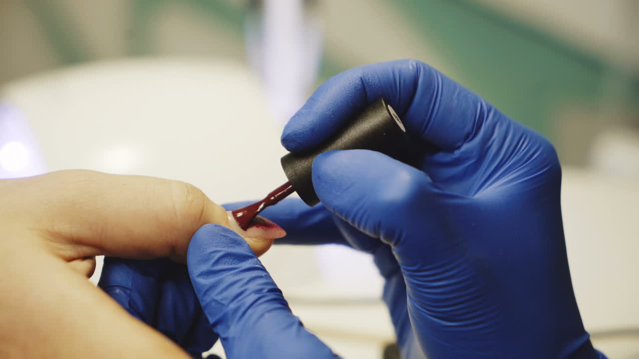 una mujer se pinta las uñas.