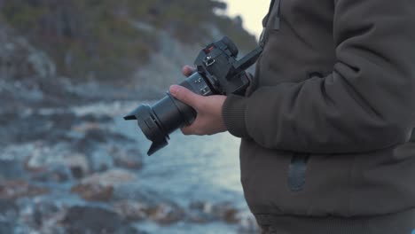 un joven se acerca la cámara a los ojos filmando junto al mar