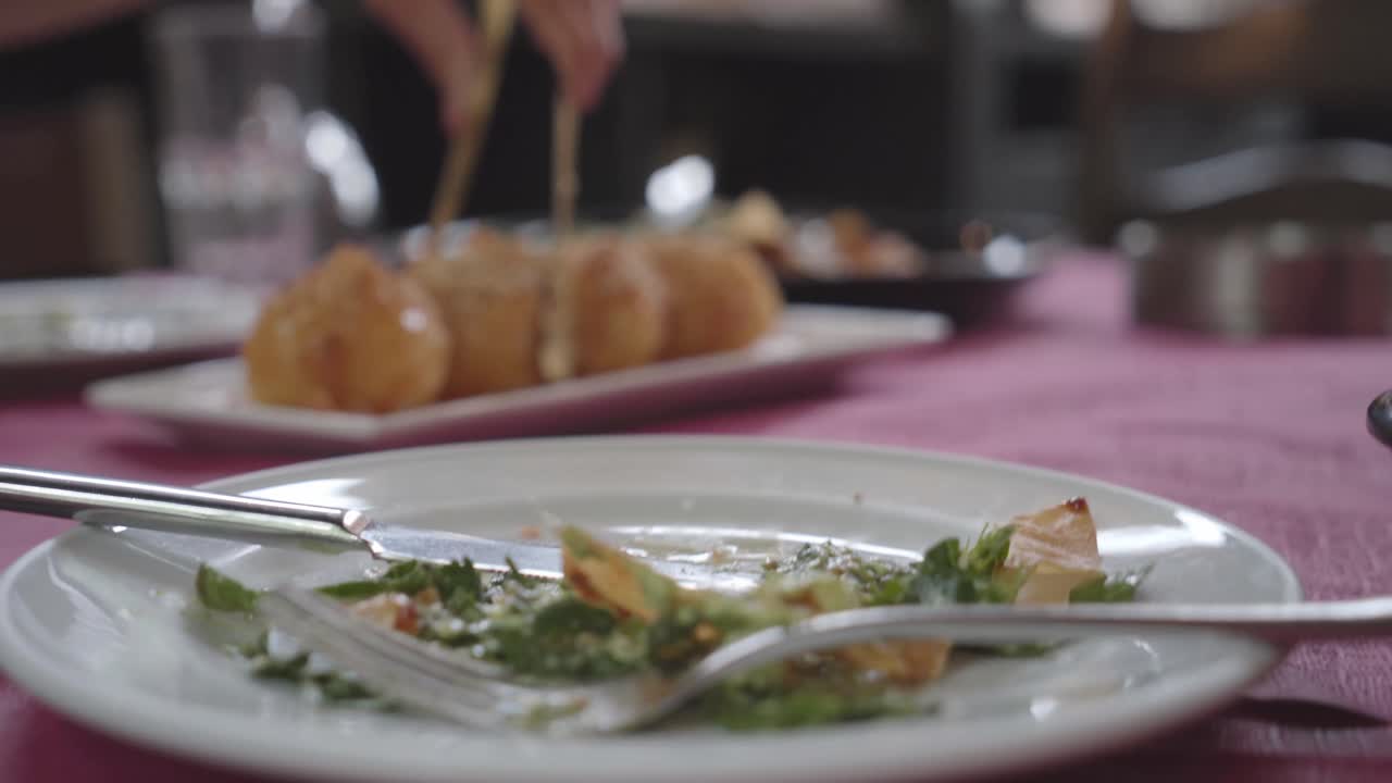 Greek Honey ball being transported by a server to a plate, first person view
