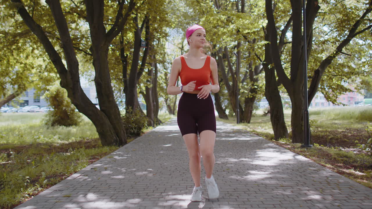 Athletic fitness sport runner girl training marathon run, listening music in earphones, morning park