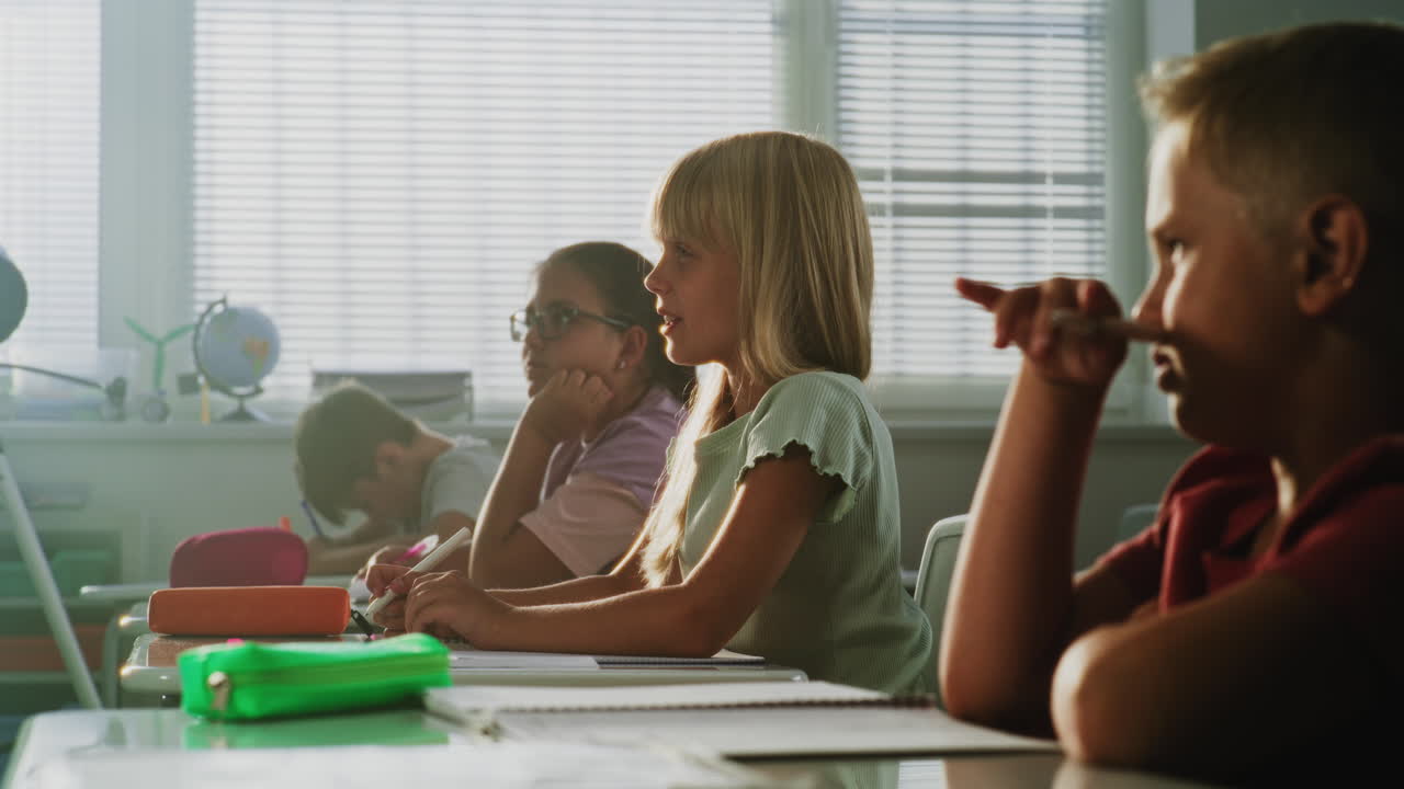 Elementary School Students Raising Hands to Provide Correct Answer During Geography Lesson