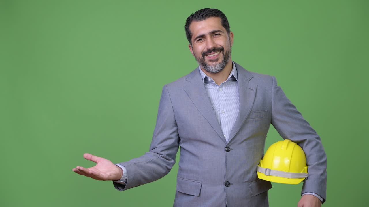 Handsome Persian bearded businessman as engineer showing something