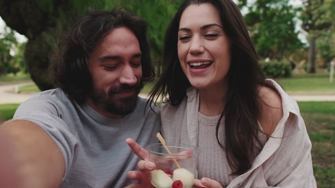Casal saboreando a sobremesa durante um piquenique no parque