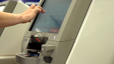 airport kiosk passenger prints boarding pass