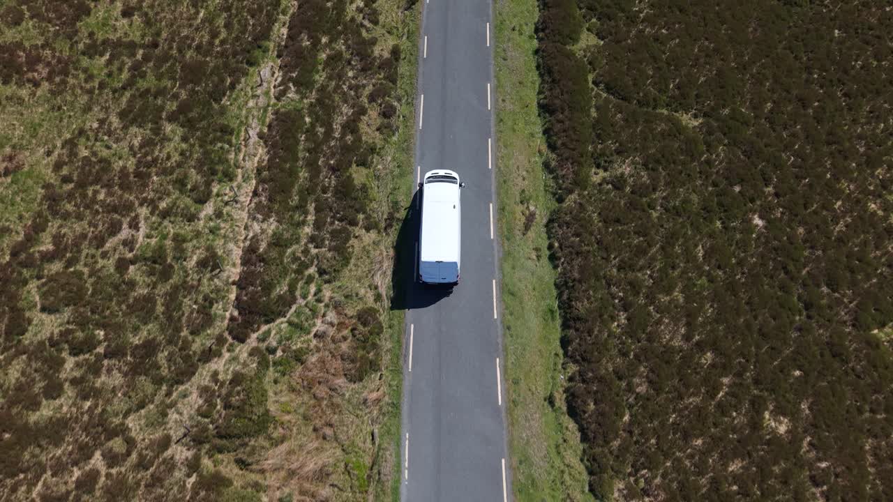 Un furgone bianco in un epico viaggio su strada attraverso le montagne di Wicklow in Irlanda. Vista aerea.