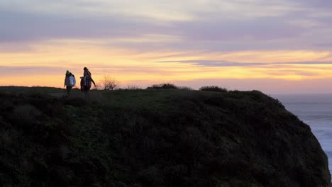 Group-of-people-walking-away-after-observing-an-amazing-sunset-in-Half-Moon-Bay,-California