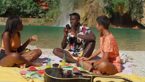 black man taking photo of women sitting on beach