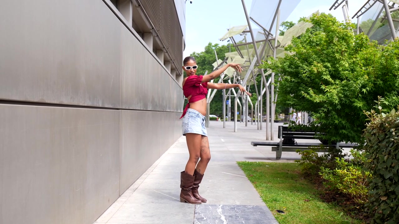 Mujer joven feliz bailando al aire libre con un atuendo de moda