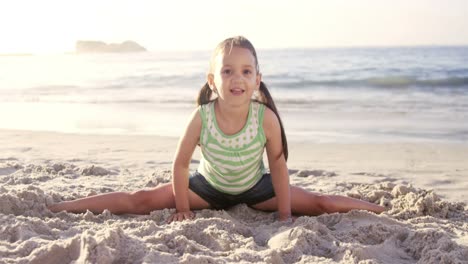 Cute-girl-doing-split-on-the-beach