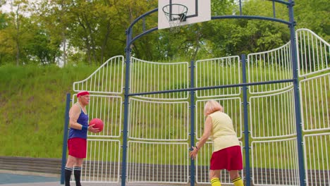 Un-Hombre-Y-Una-Mujer-Del-Viejo-Equipo-De-Baloncesto-Jugando,-Lanzando-La-Pelota-A-La-Canasta-En-La-Cancha-Del-Estadio