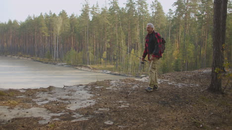 travelling-in-woodland-area-man-with-rod-is-walking-to-coast-of-river-to-fishing-rest-of-fisherman-at-nature