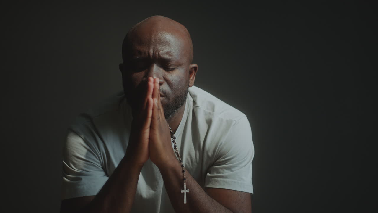 Faithful Man Holding Cross and Praying Deeply to God
