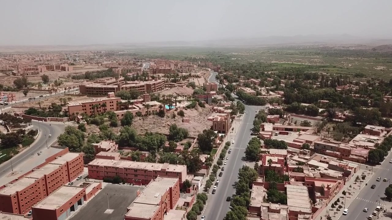 Veduta aerea con drone di Ouarzazate, la porta del Marocco verso il Sahara, che mostra il suo ambiente da oasi, il patrimonio culturale e il suo ruolo di destinazione principale per il turismo nel deserto.