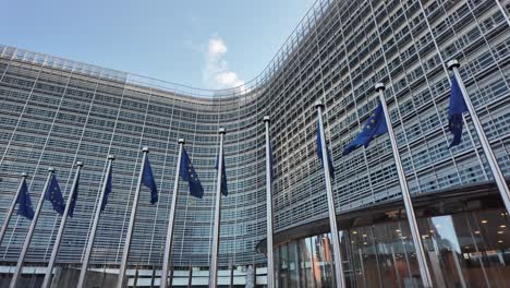 european commission headquarters with eu flags in brussels