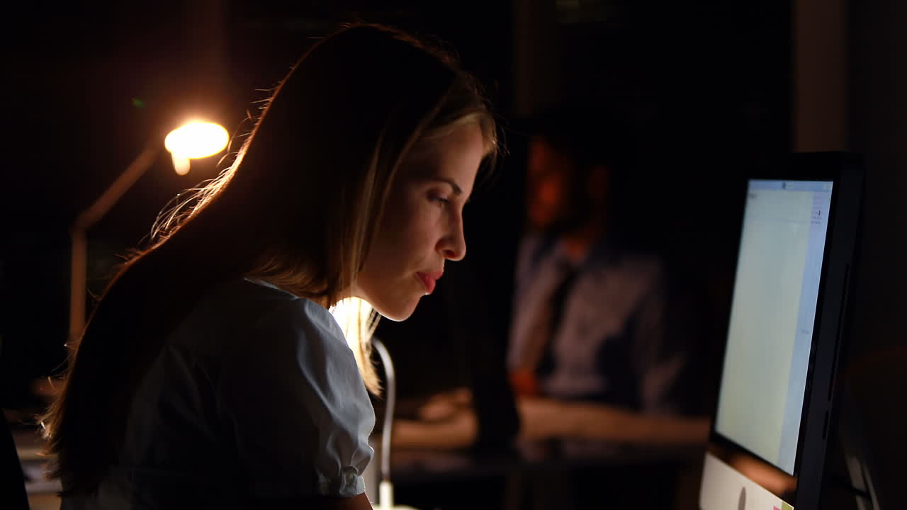 Donna d'affari che usa il computer di notte