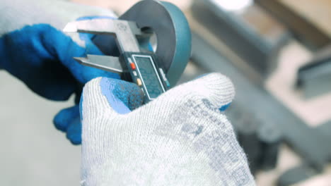 trabajador midiendo el diámetro interior de la parte de hierro con un calibrador electrónico