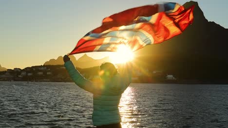 Frau-Schwenkt-Bei-Sonnenuntergang-Die-Flagge-Norwegens