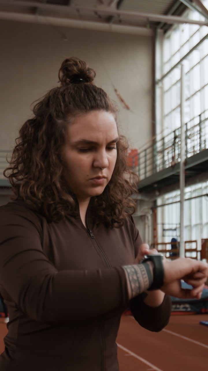 Woman checking her smartwatch during a workout in a gym