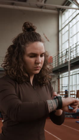 woman checking her smartwatch during a workout in a gym