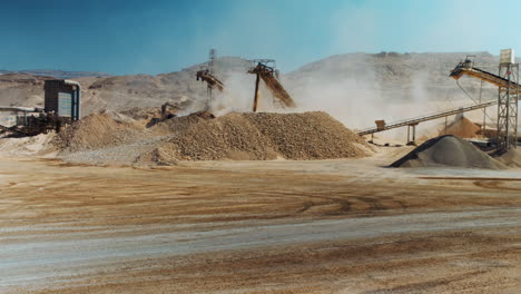 industrial sand mining - wide shot - pan right for a mining machinery industrial area, mining equipment working. 4k footage