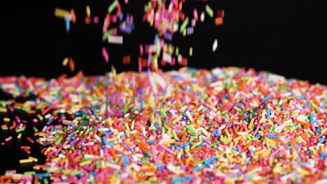 hands interacting with colorful sprinkles on surface