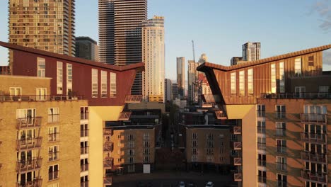 lighting luxury apartment blocks and the shore of river thames during golden sunset