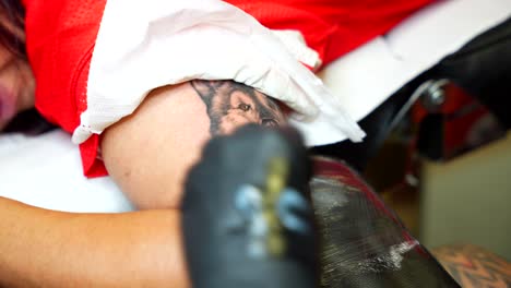 tattoo artist using white ink to paint the eye of a dog tattoo and make it more realistic