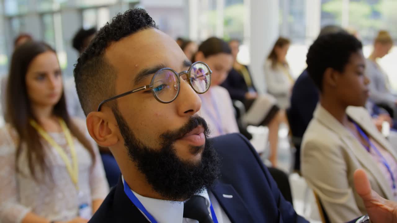 Uomo d'affari di etnia mista con il relatore al seminario aziendale 4k