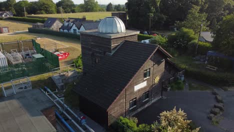 Aerial-view-Pex-hill-Leighton-observatory-silver-dome-rooftop-on-hilltop-farmland-at-sunrise,-low-orbit-right