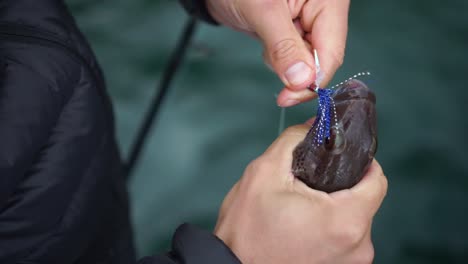 SLOWMO---Male-fisherman-takes-out-fish-hook-on-boat---close-up