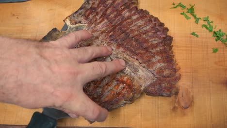 a slab of perfectly sliced pork steak is placed on a wooden cutting board