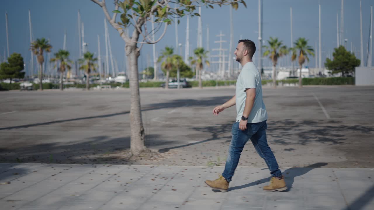 Man walking with smartphone in a marina