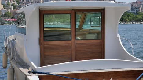 small white boat with wooden cabin on the water