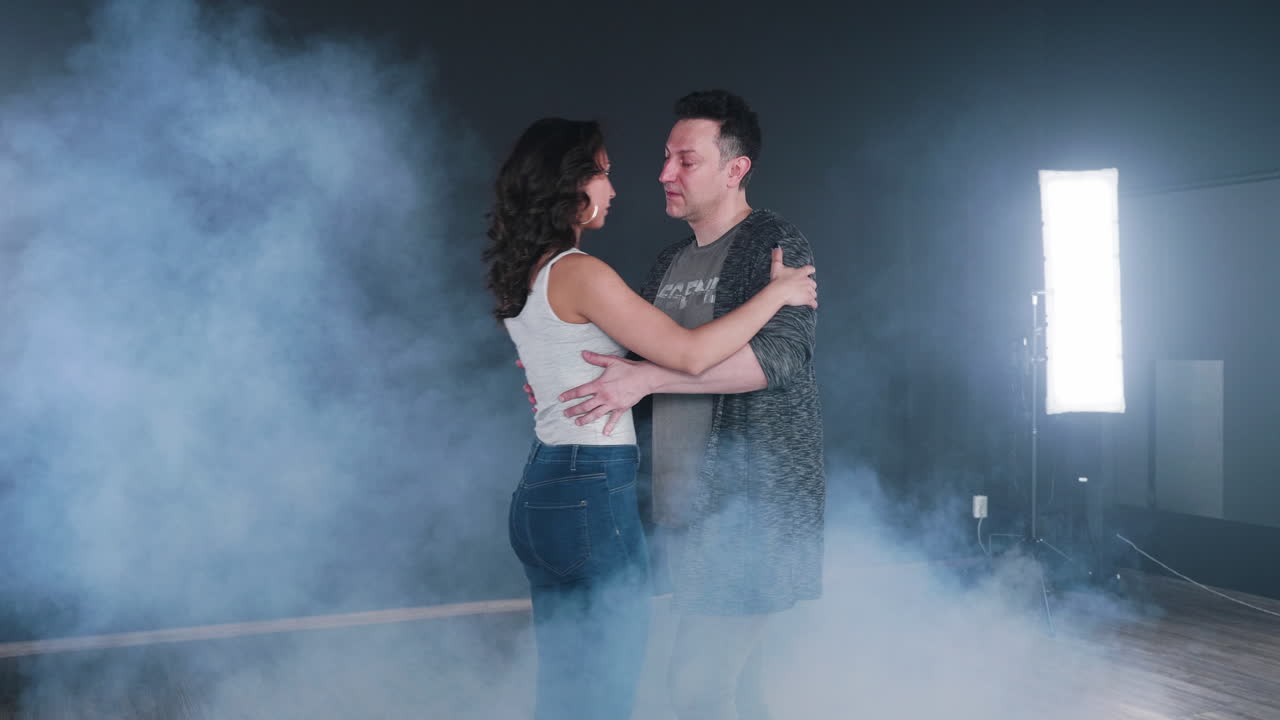 Couple dancing in a smoky studio