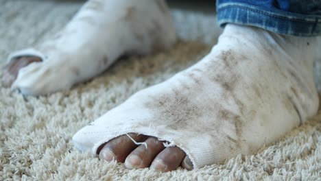 closeup of a man's feet with worn-out socks