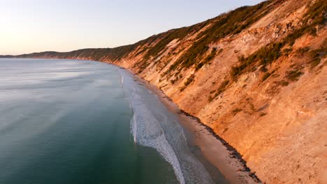 Vuelo-Temprano-Al-Amanecer-Alrededor-De-La-Playa-Del-Arco-Iris-En-Queensland,-Australia