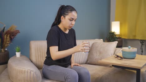 Cowardly-young-woman-drinks-water-with-trembling-hand.