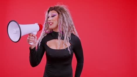 drag queen speaking into a megaphone on a red background