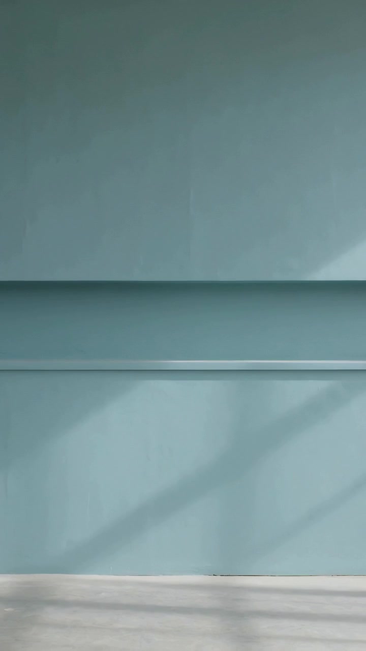 Vertical video: Shifting slatted shadows sliding across blue wall with two ledges in room from sun