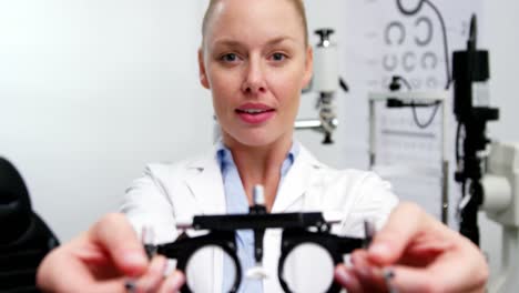 smiling female optometrist holding messbrille