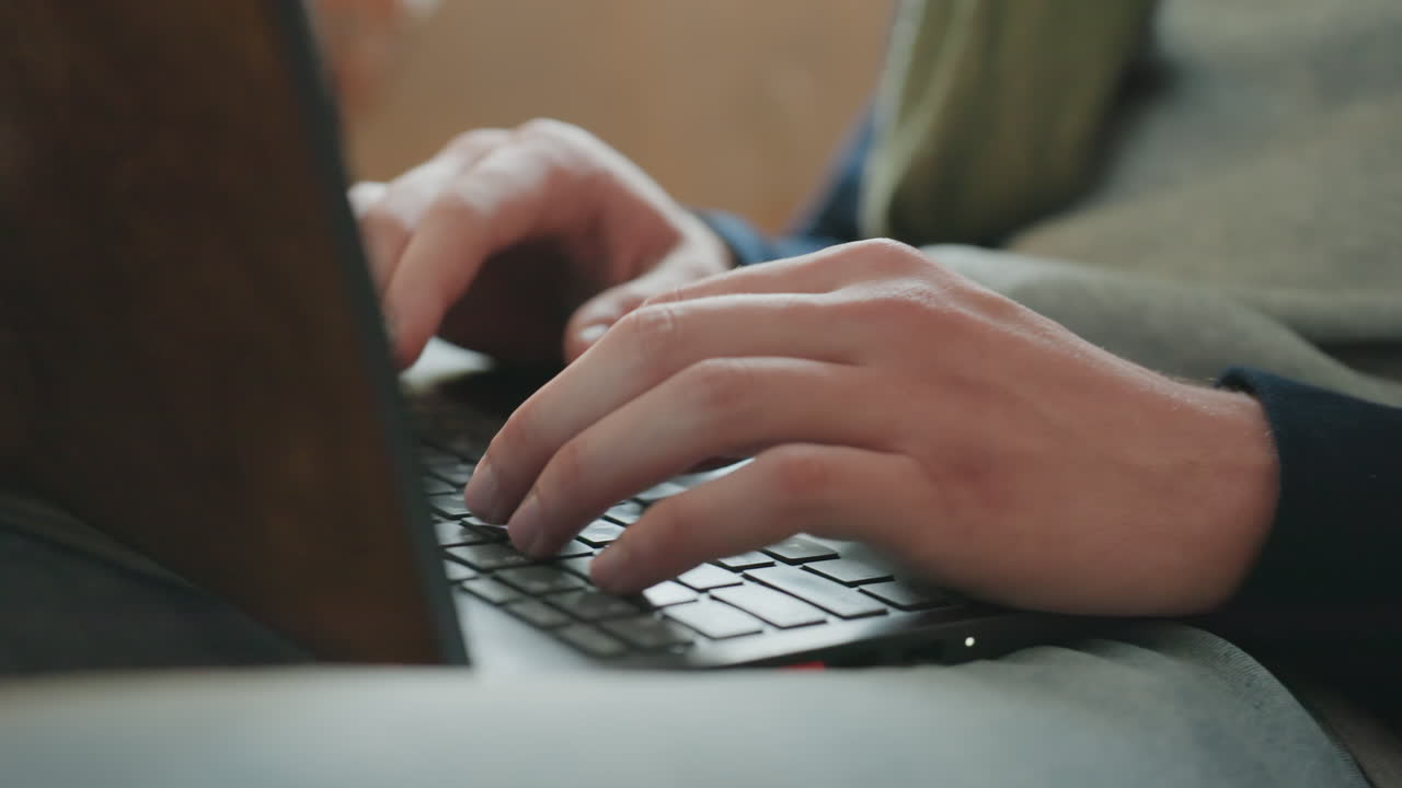 Mani che digitano sulla tastiera del laptop, studente universitario che fa ricerca per un compito durante una sessione di studio a tarda notte con taccuino e caffè, dita attente che scorrono gli appunti, concentrazione costante