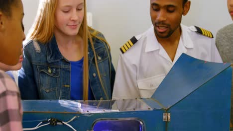 male pilot explaining about machine to kids 4k