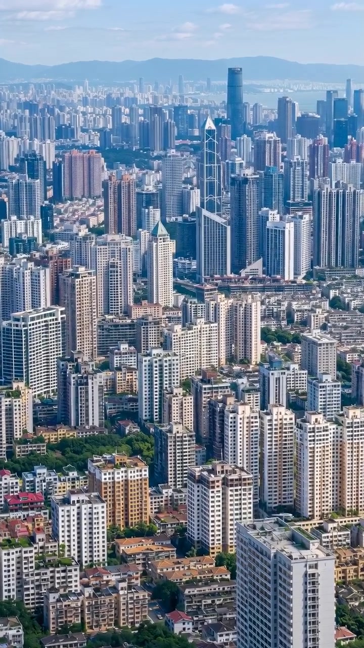 Perspectiva aérea em movimento sobre um denso horizonte metropolitano, mostrando aglomerados em camadas de moradias de baixa altura, apartamentos de média altura e torres comerciais de arranha-céus estendendo-se em direção ao horizonte distante com.